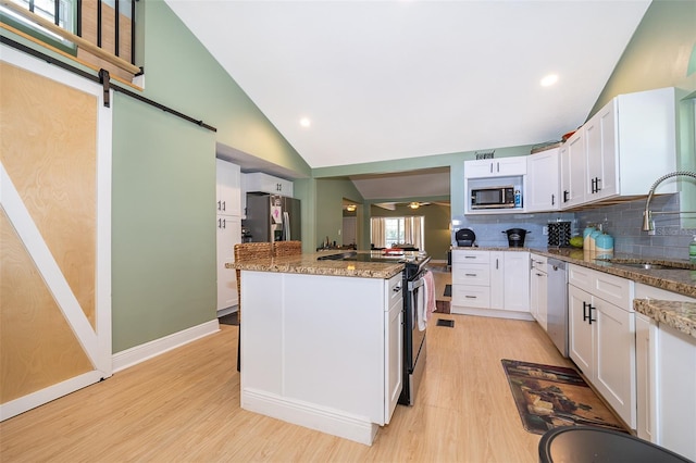 kitchen featuring light hardwood / wood-style flooring, white cabinetry, appliances with stainless steel finishes, backsplash, and sink