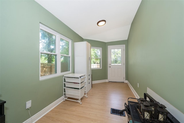 interior space with light hardwood / wood-style flooring and vaulted ceiling