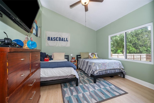 bedroom with ceiling fan, light wood-type flooring, and lofted ceiling