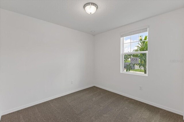 carpeted empty room with a textured ceiling