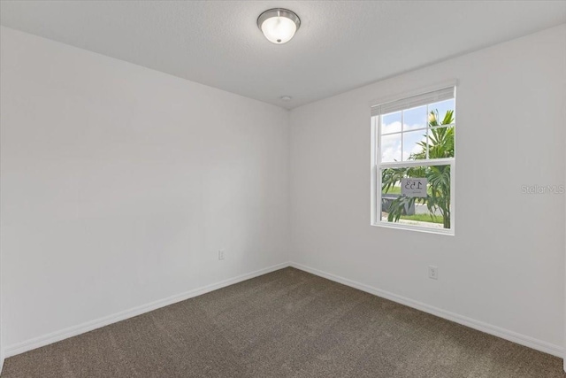 carpeted empty room featuring a textured ceiling