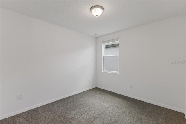 spare room featuring carpet floors and a textured ceiling