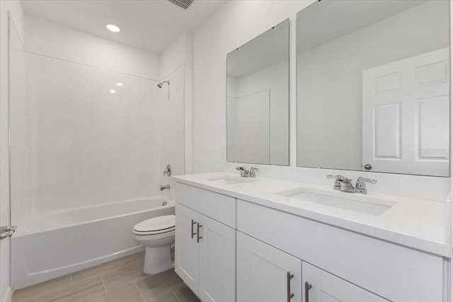 full bathroom featuring vanity, tiled shower / bath combo, and toilet