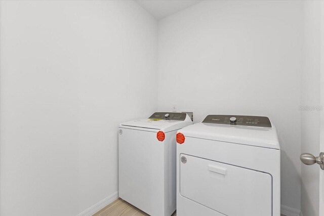 laundry room featuring light hardwood / wood-style floors and independent washer and dryer