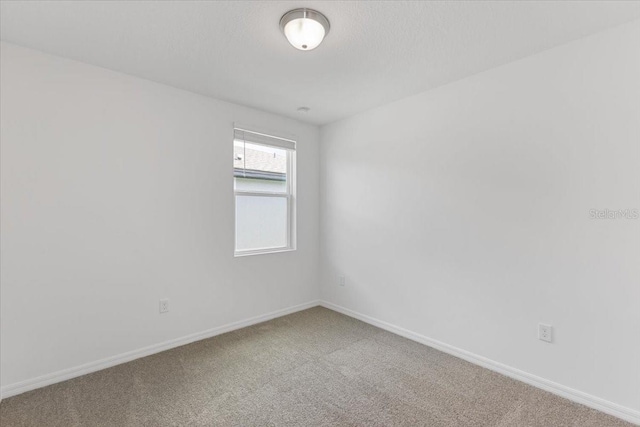 spare room with a textured ceiling and carpet flooring