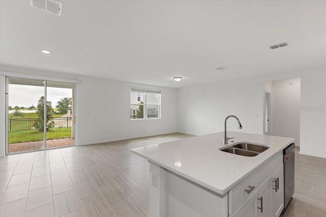 kitchen featuring white cabinetry, dishwasher, sink, and a center island with sink