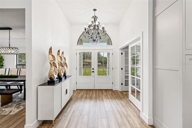 entryway featuring a chandelier, light hardwood / wood-style floors, and french doors