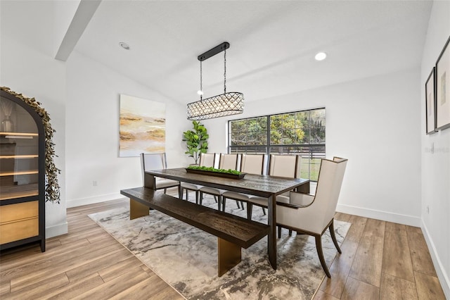 dining space with light hardwood / wood-style flooring and vaulted ceiling