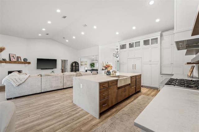 kitchen featuring sink, light hardwood / wood-style floors, a center island, and white cabinets