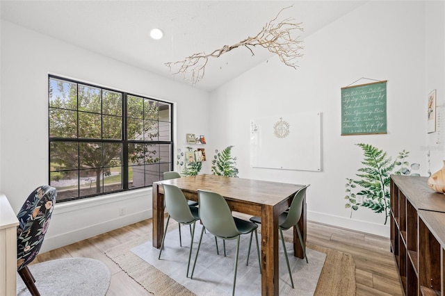 dining space with lofted ceiling and light hardwood / wood-style floors