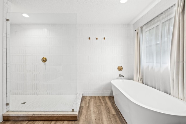 bathroom with hardwood / wood-style flooring and separate shower and tub