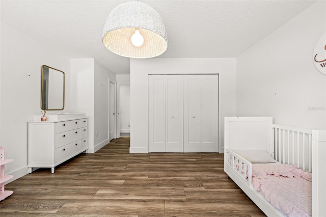 unfurnished bedroom with a closet, dark hardwood / wood-style floors, and a textured ceiling