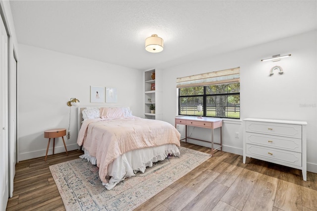 bedroom featuring hardwood / wood-style flooring and a textured ceiling