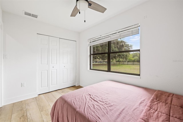 bedroom with a closet, ceiling fan, and light wood-type flooring