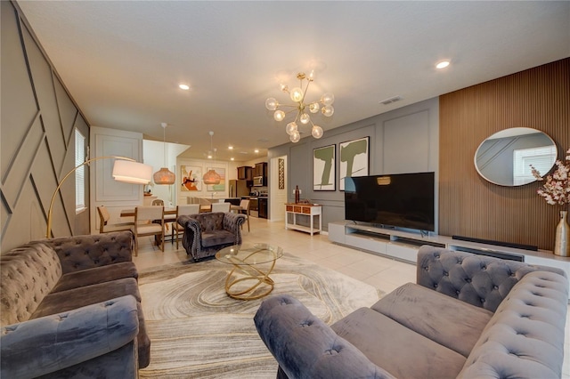 living area with light tile patterned floors, a chandelier, a decorative wall, and recessed lighting