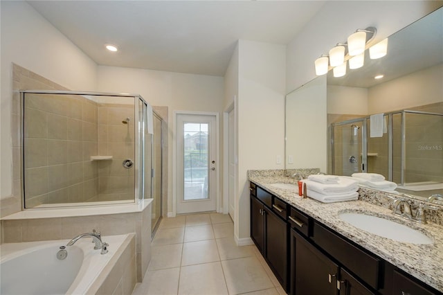 full bath with a sink, a bath, tile patterned floors, double vanity, and a stall shower