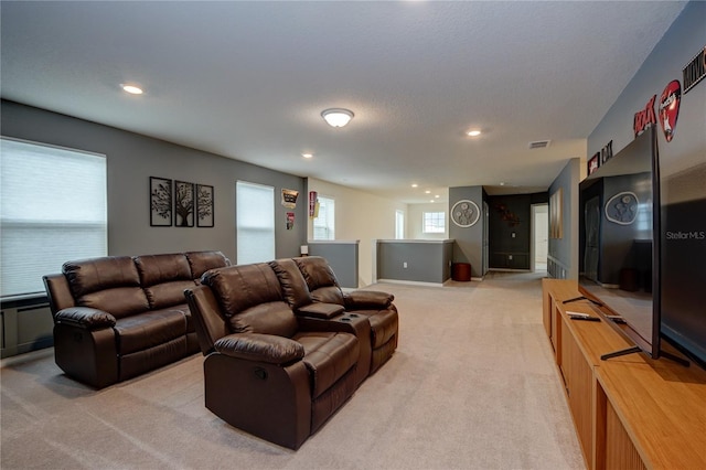 living area featuring light carpet, visible vents, and recessed lighting