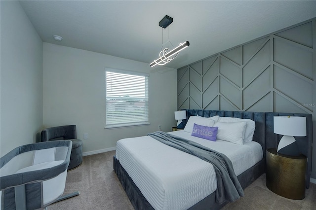 carpeted bedroom featuring a chandelier and baseboards