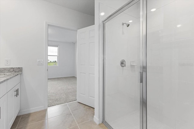 bathroom featuring tile patterned floors, an enclosed shower, and vanity