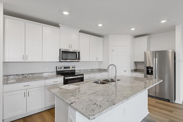 kitchen featuring appliances with stainless steel finishes, sink, a center island with sink, and white cabinets