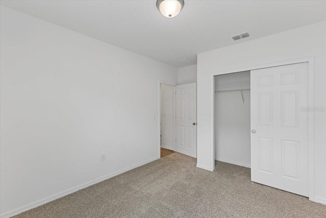 unfurnished bedroom with light carpet and a closet