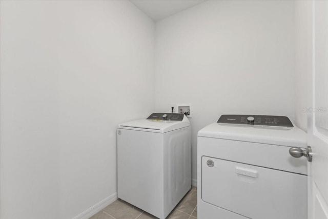 washroom with washer and clothes dryer and light tile patterned floors