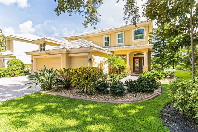 mediterranean / spanish-style home featuring a garage and a front yard