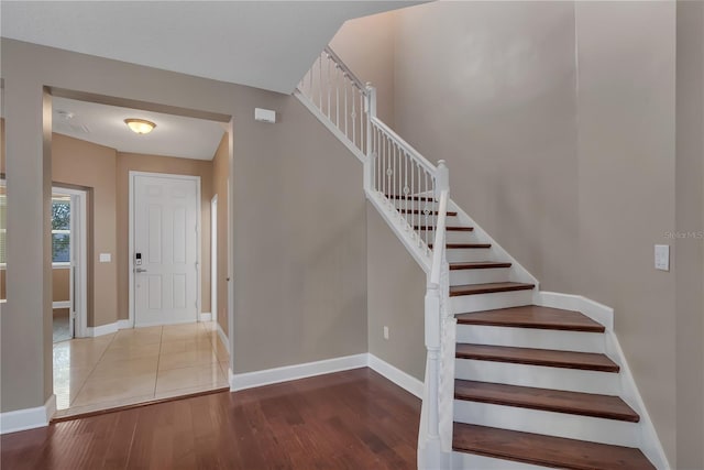 staircase with hardwood / wood-style floors