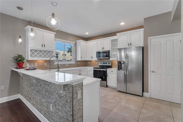 kitchen featuring decorative backsplash, pendant lighting, stainless steel appliances, and white cabinetry