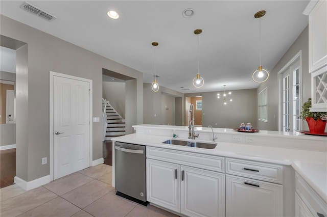 kitchen with light wood-type flooring, white cabinets, stainless steel dishwasher, hanging light fixtures, and sink