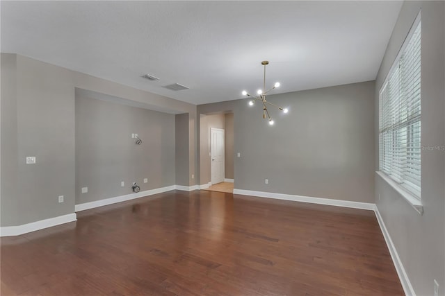 unfurnished room with dark hardwood / wood-style flooring and a chandelier