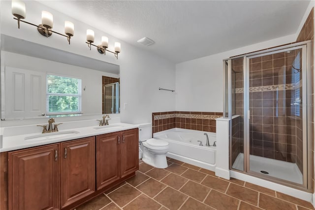 full bathroom featuring tile patterned floors, independent shower and bath, dual vanity, toilet, and a textured ceiling