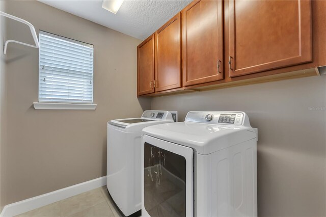 washroom featuring cabinets, independent washer and dryer, and light tile patterned floors