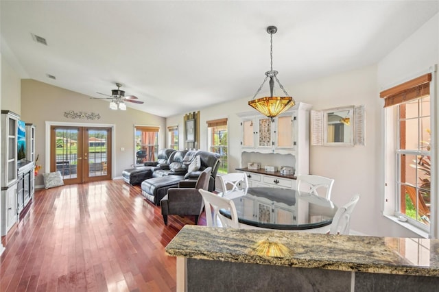 dining area with ceiling fan, lofted ceiling, dark hardwood / wood-style flooring, and french doors