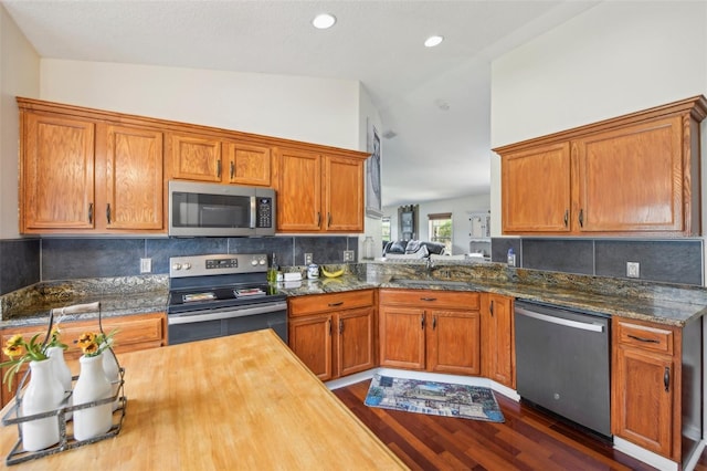 kitchen with lofted ceiling, butcher block countertops, sink, dark hardwood / wood-style floors, and stainless steel appliances