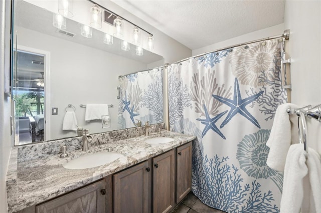 bathroom featuring vanity, tile patterned floors, and a textured ceiling