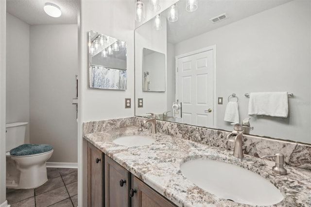 bathroom featuring vanity, a textured ceiling, tile patterned floors, and toilet