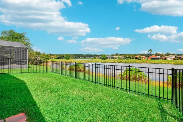 view of yard with a water view and glass enclosure