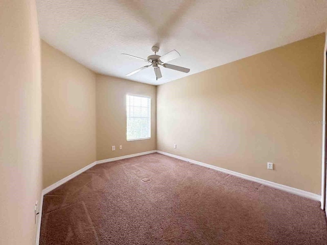 carpeted spare room with a textured ceiling and ceiling fan