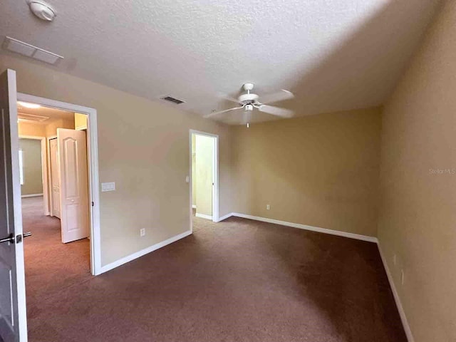 carpeted spare room with ceiling fan and a textured ceiling