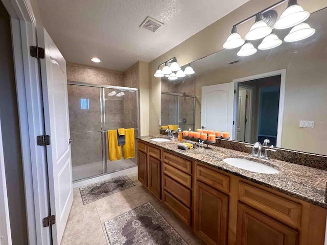 bathroom featuring vanity, tile patterned floors, a textured ceiling, and walk in shower