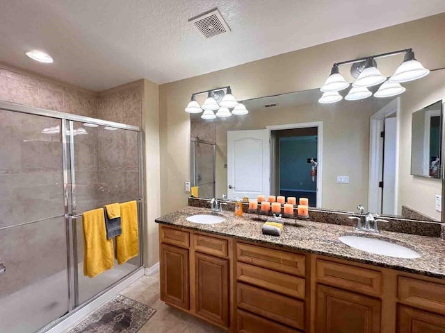 bathroom featuring tile patterned flooring, vanity, and walk in shower