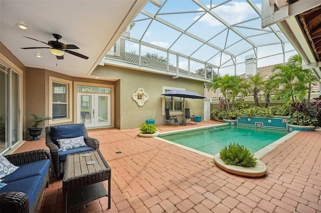 view of swimming pool with glass enclosure, ceiling fan, french doors, and a patio area