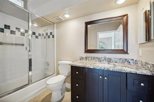 full bathroom featuring enclosed tub / shower combo, vanity, and toilet