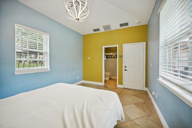 bedroom with light tile patterned flooring, a notable chandelier, and connected bathroom