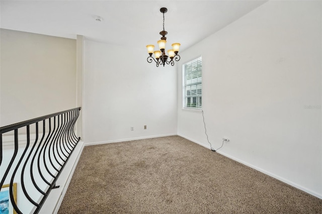 empty room with an inviting chandelier and carpet