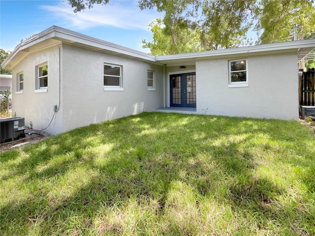 rear view of property with french doors, a yard, and central air condition unit