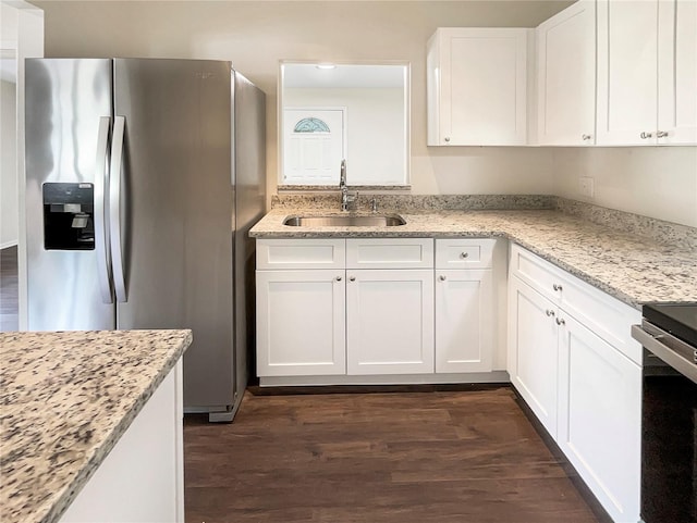 kitchen featuring sink, white cabinetry, dark hardwood / wood-style floors, light stone countertops, and stainless steel fridge with ice dispenser