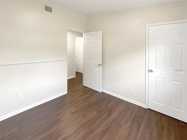 unfurnished bedroom with dark hardwood / wood-style floors