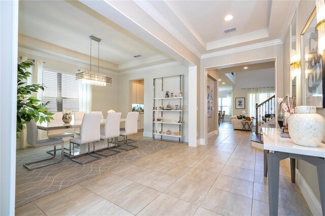 tiled dining space featuring a tray ceiling and ornamental molding